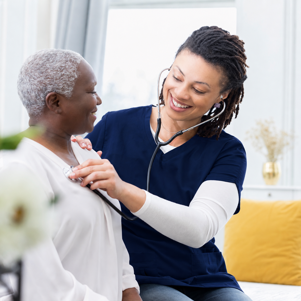 Nurse using stethoscope on elderly patient
