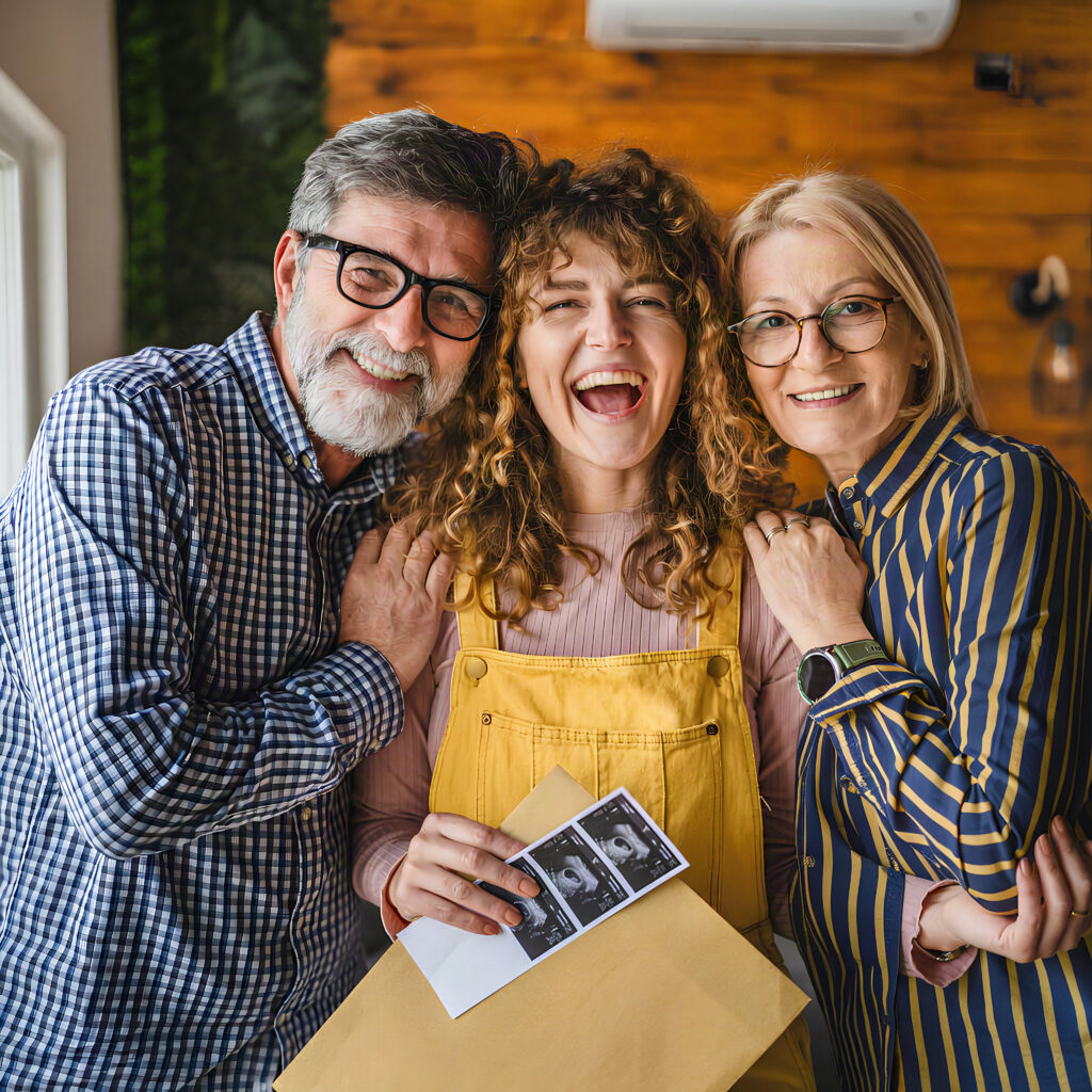 Smiling family holding pregnancy ultrasound photos